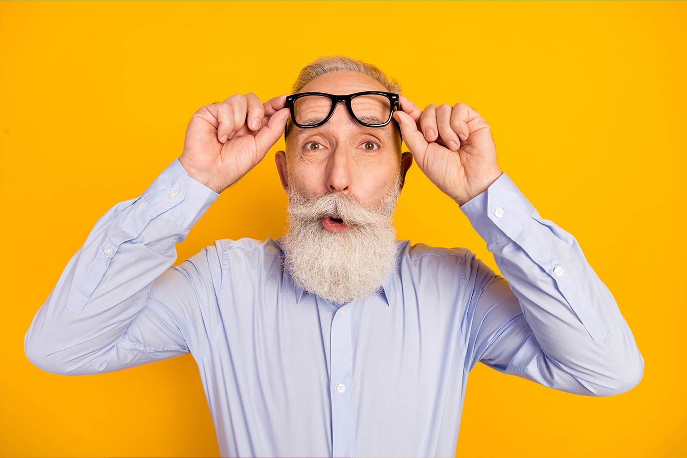Senior man with beard raising glasses