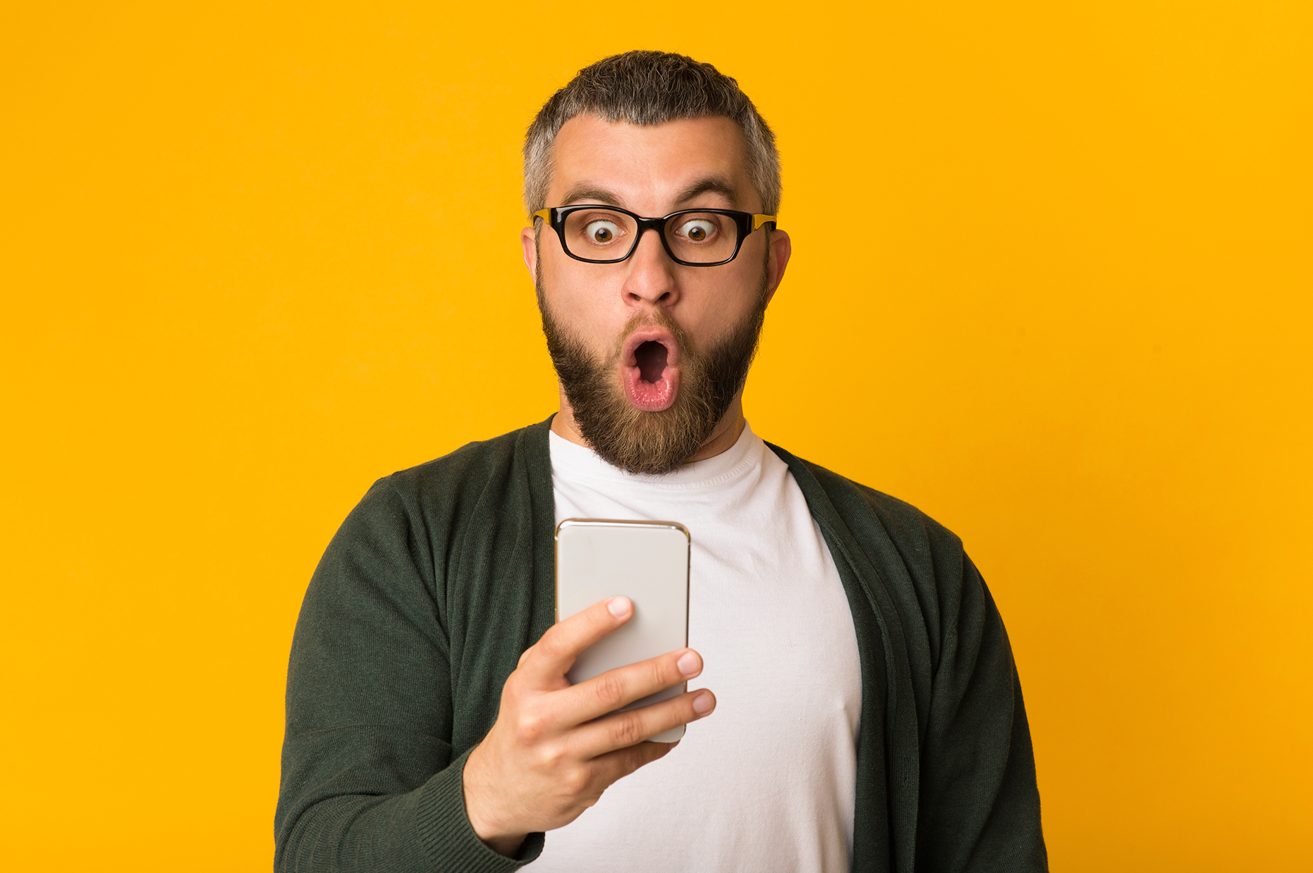 Aging man looking in shock at his cell phone